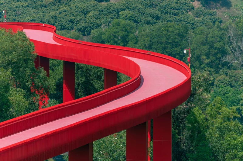 A long red winding bridge shuttles through the forest in Hongqiao Park, Guangming New District, Shenzhen, Guangdong, China